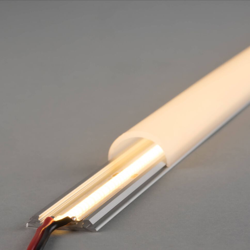 biegbares LED Alu FLEX Profil mit weißer runder Abdeckung. Verbauter COB LED Streifen leuchtet warmweiß und leuchtet die komplette Abdeckung aus.