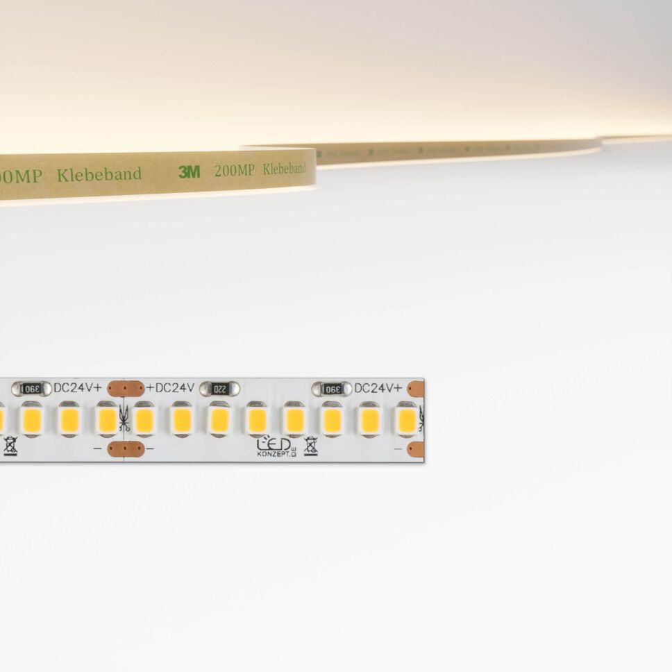High Power LED Streifen mit 21W pro Meter und 3000K, oben im Bild ist die Lichtfarbe des LED Streifens und seine flexible Leiterplatte zu sehen. Produktbild, freigestellt vor grauen Hintergrund