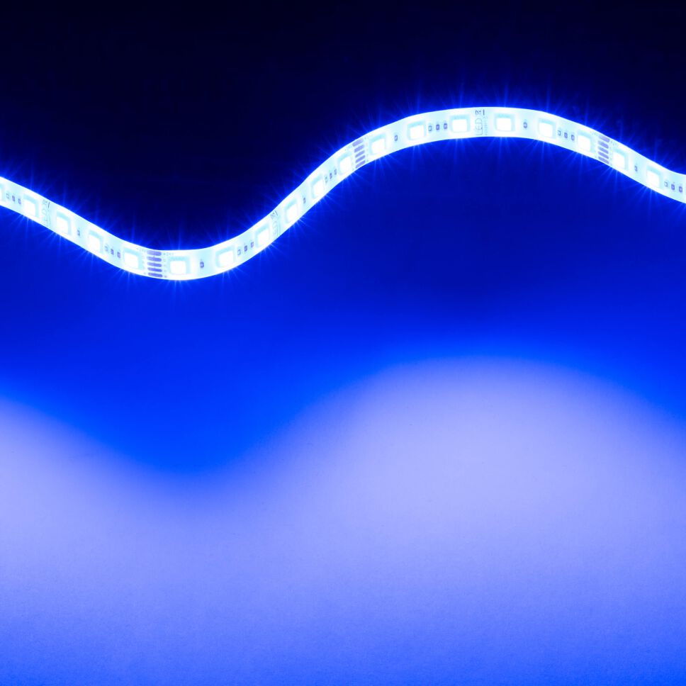 leuchtender RGB-W LED Streifen, der flexible LED Streifen leuchtet blau und liegt zu einer Lichtwelle gebogen