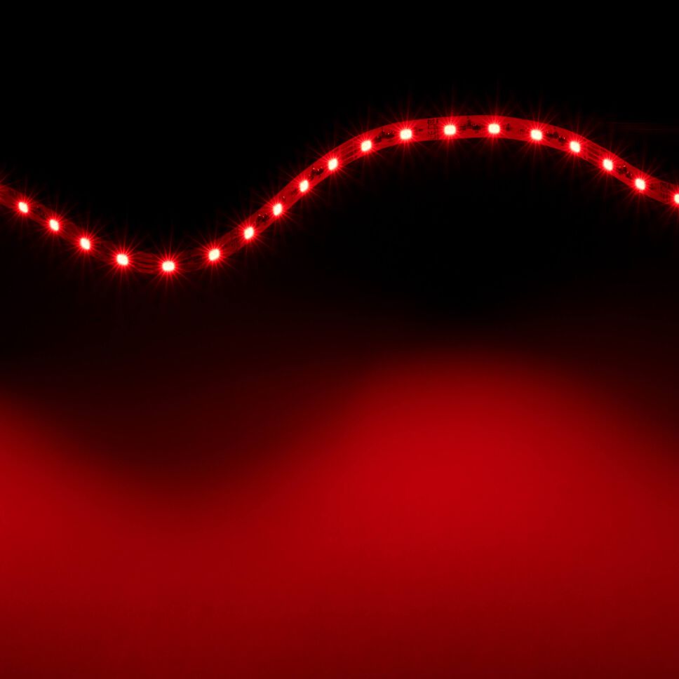 rot leuchtender IC RGB LED Streifen, lediglich der rote Kanal ist eingeschaltet und emittiert rotes Licht, flexibler Streifen ist zur Lichtwelle gelegt