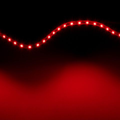 rot leuchtender IC RGB LED Streifen, lediglich der rote Kanal ist eingeschaltet und emittiert rotes Licht, flexibler Streifen ist zur Lichtwelle gelegt