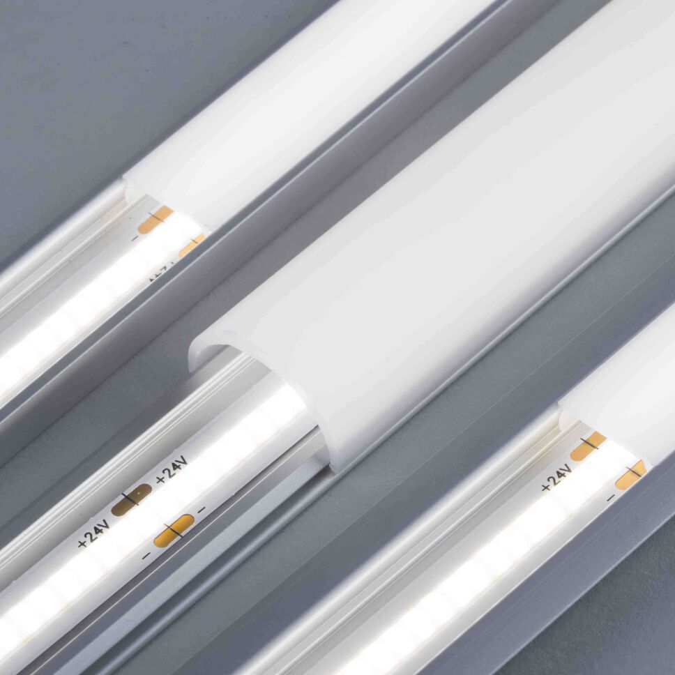 Fotografie mehrerer flacher LED Alu Profile, bestückt mit COB LED Streifen. Abdeckung ist homogen ausgeleuchtet und leuchtet neutralweiß
