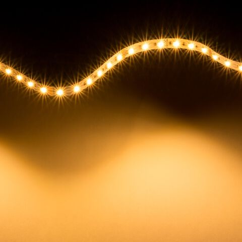 warmweiß leuchtender RGB+CCT LED Streifen mit flexibler Leiterplatte zur Lichtwelle gelegt