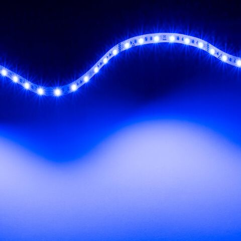 leuchtender RGB2W LED Streifen, der flexible LED Streifen leuchtet blau und liegt zu einer Lichtwelle gebogen