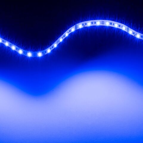 leuchtender RGB2W LED Streifen, der flexible LED Streifen leuchtet blau und liegt zu einer Lichtwelle gebogen