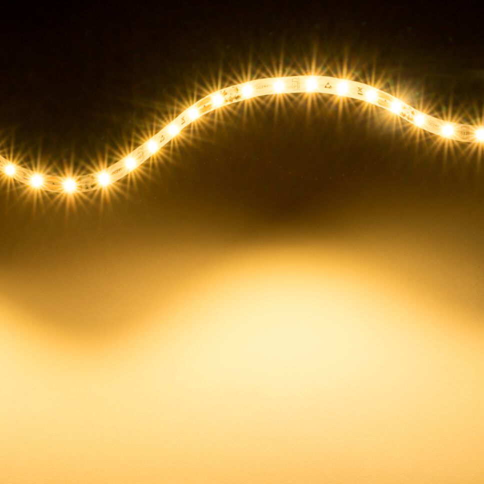 leuchtender LED Streifen mit 2700K warmweiß und flexibler Leiterplatte. Streifen zu einer Lichtwelle gelegt