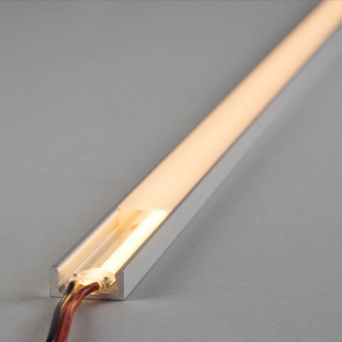 LED Alu Profil SKP mit flacher opaler Abdeckung. Installierter COB LED Streifen leuchet warmweiß und beleuchtet die komplette Abdeckung des LED Alu Profils aus.